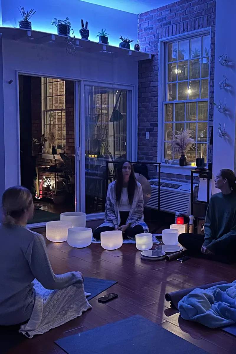 Guests seated around glowing crystal singing bowls