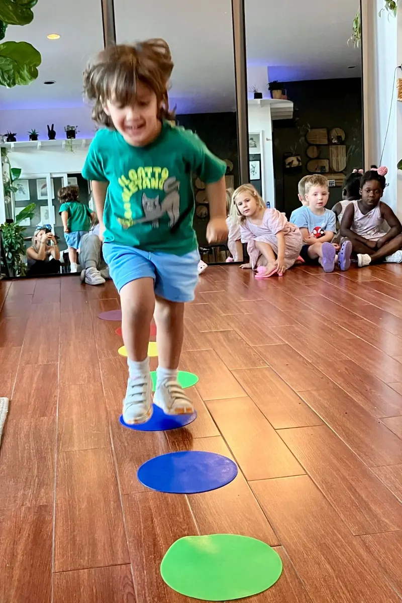 Boy hopping across colored floor dots