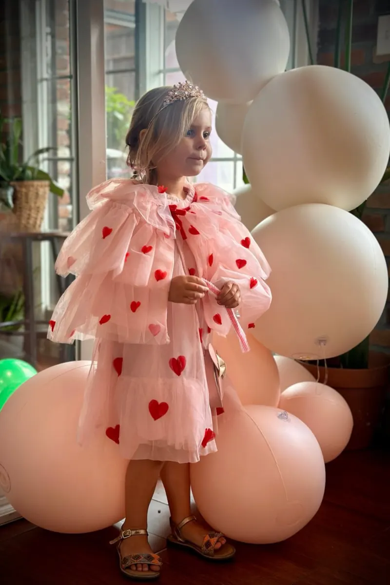 Child in a pink dress with balloons